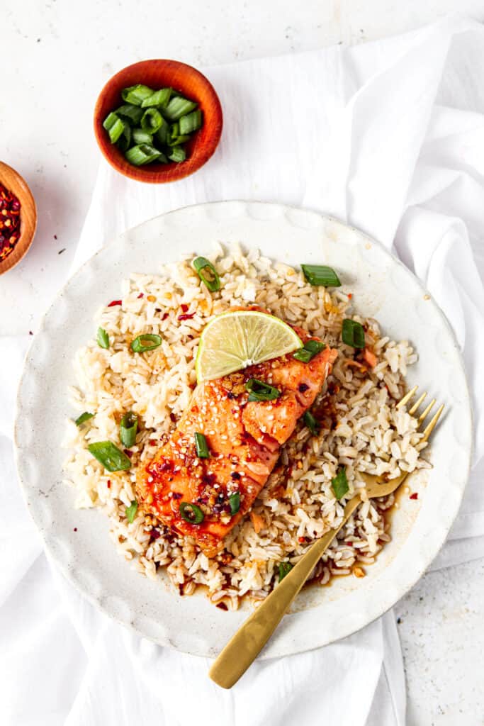 far away shot of honey sriracha salmon on a plate with rice