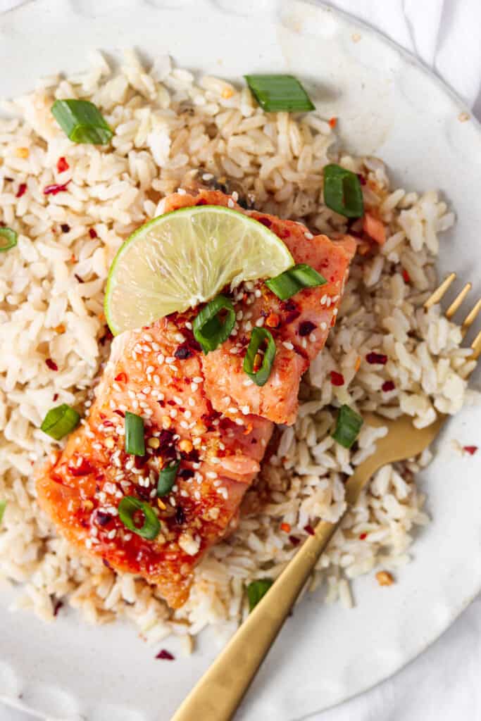 honey sriracha salmon on a plate with rice and a fork