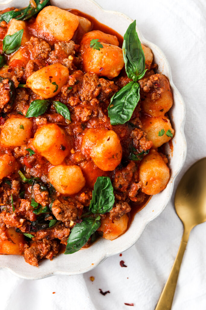 Paleo Gnocchi Bolognese in a bowl with basil garnish