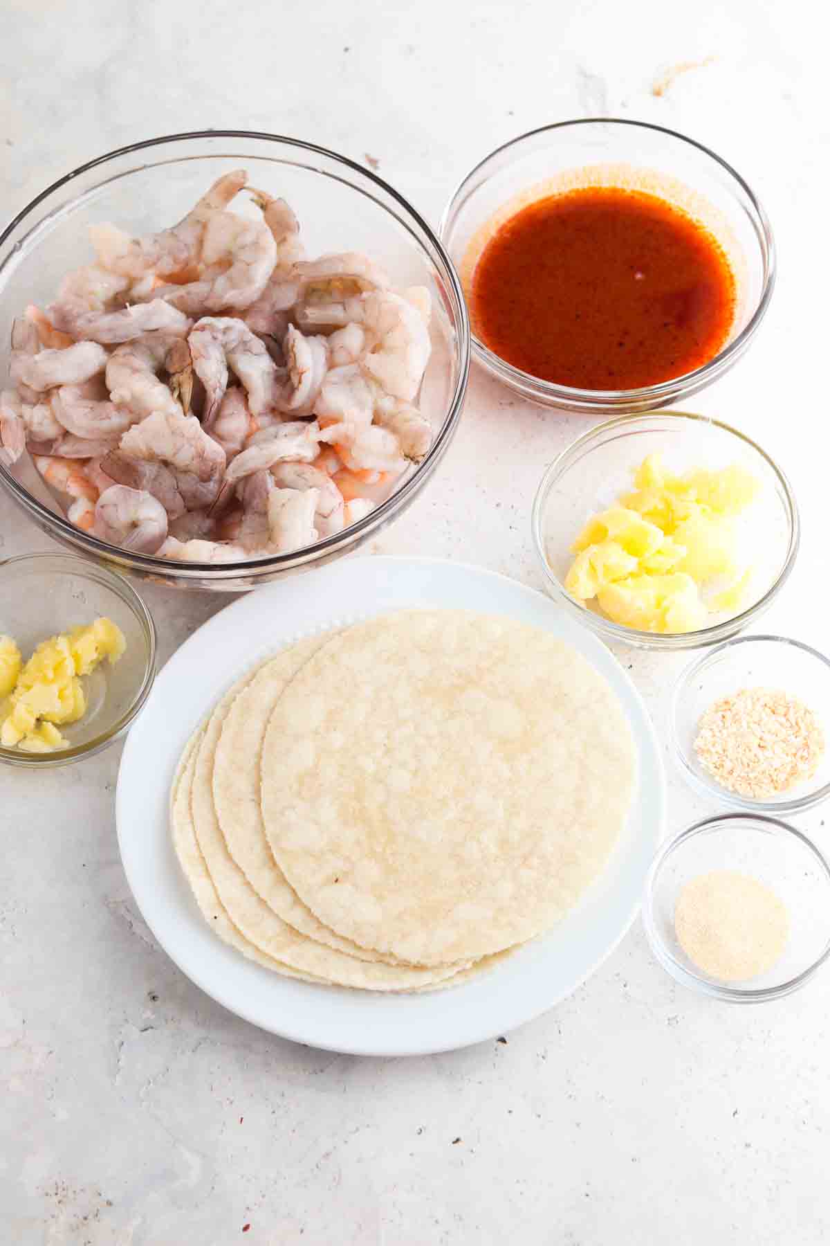 Buffalo shrimp taco ingredients laid out in small glass bowls. 