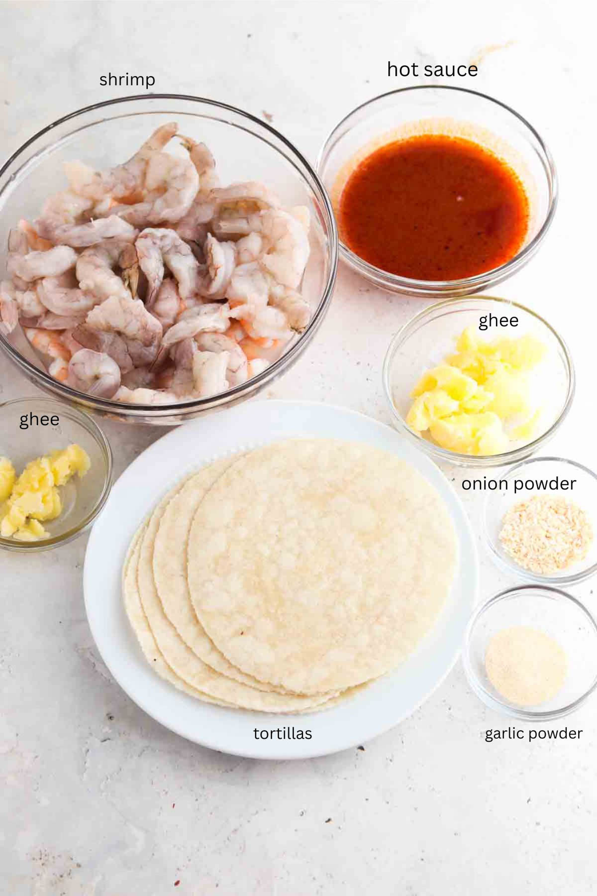 Buffalo shrimp taco ingredients laid out in small glass bowls. 