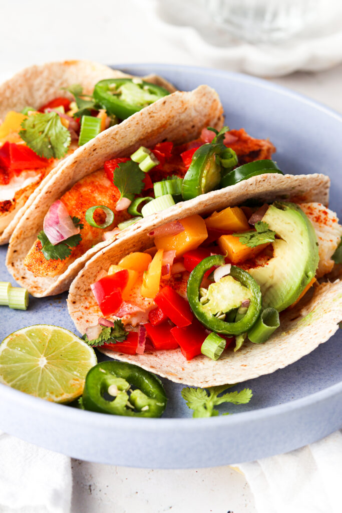 halibut fish tacos lined up in a blue bowl