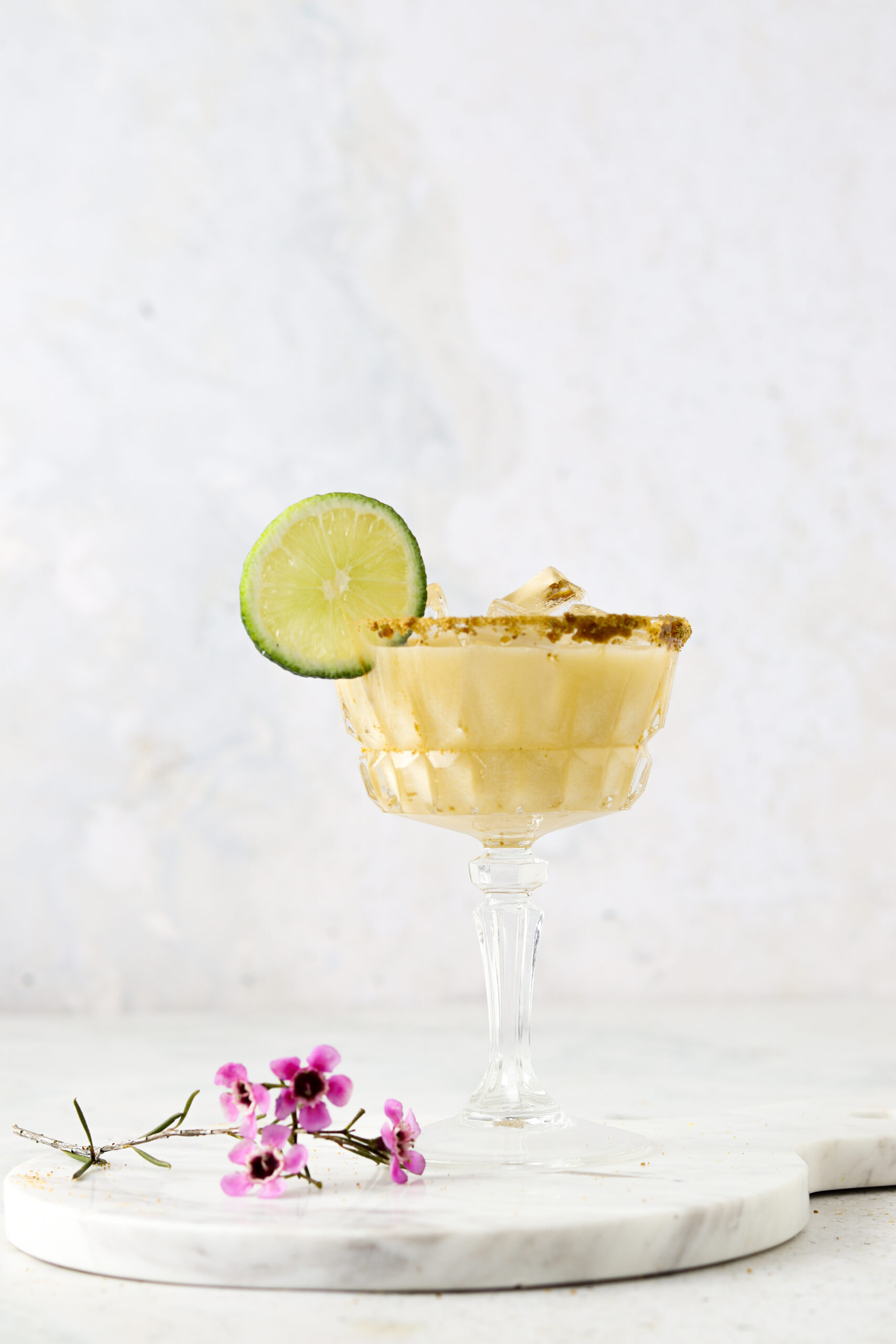 Key lime mocktail in a fun cocktail glass with a lime on the rim. 