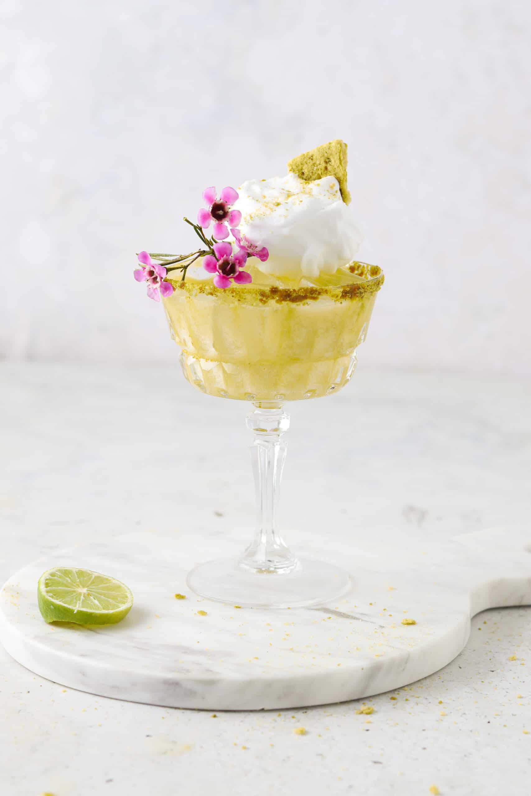 key lime pie mocktail in a cocktail glass with flowers