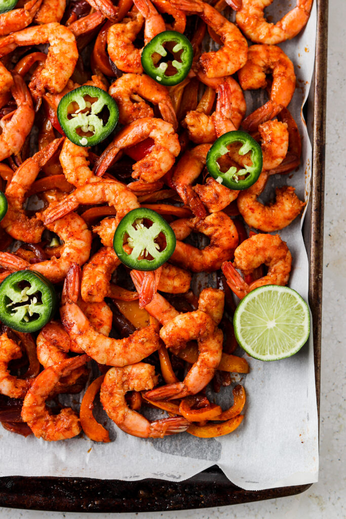 paleo sheet pan shrimp tacos on a tray with limes