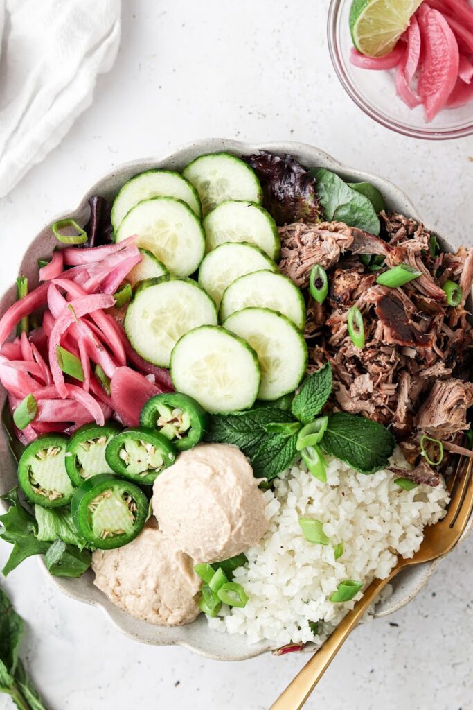 shredded lamb power bowls in a bowl with a gold fork