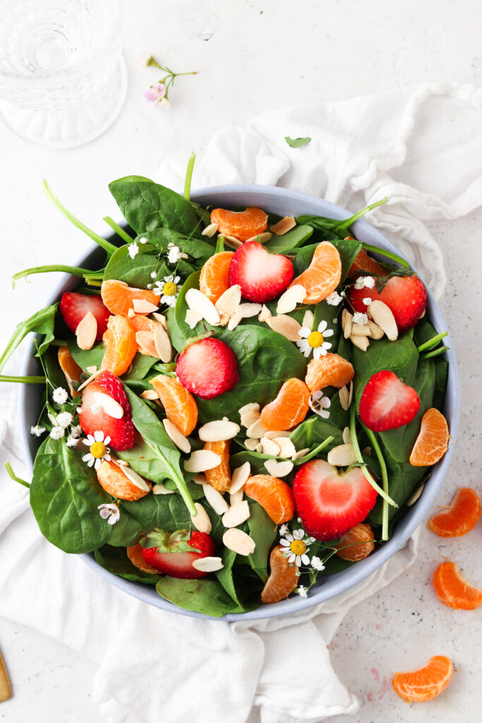 strawberry poppyseed salad with oranges in a blue bowl