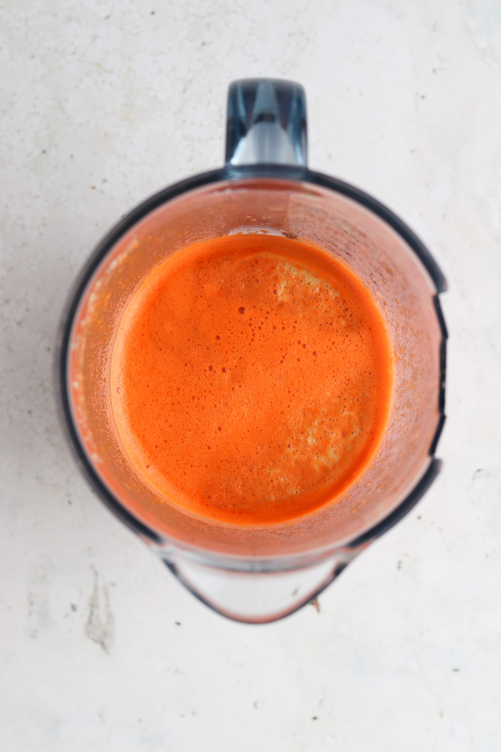 Over head shot of carrot juice in a juice pitcher.