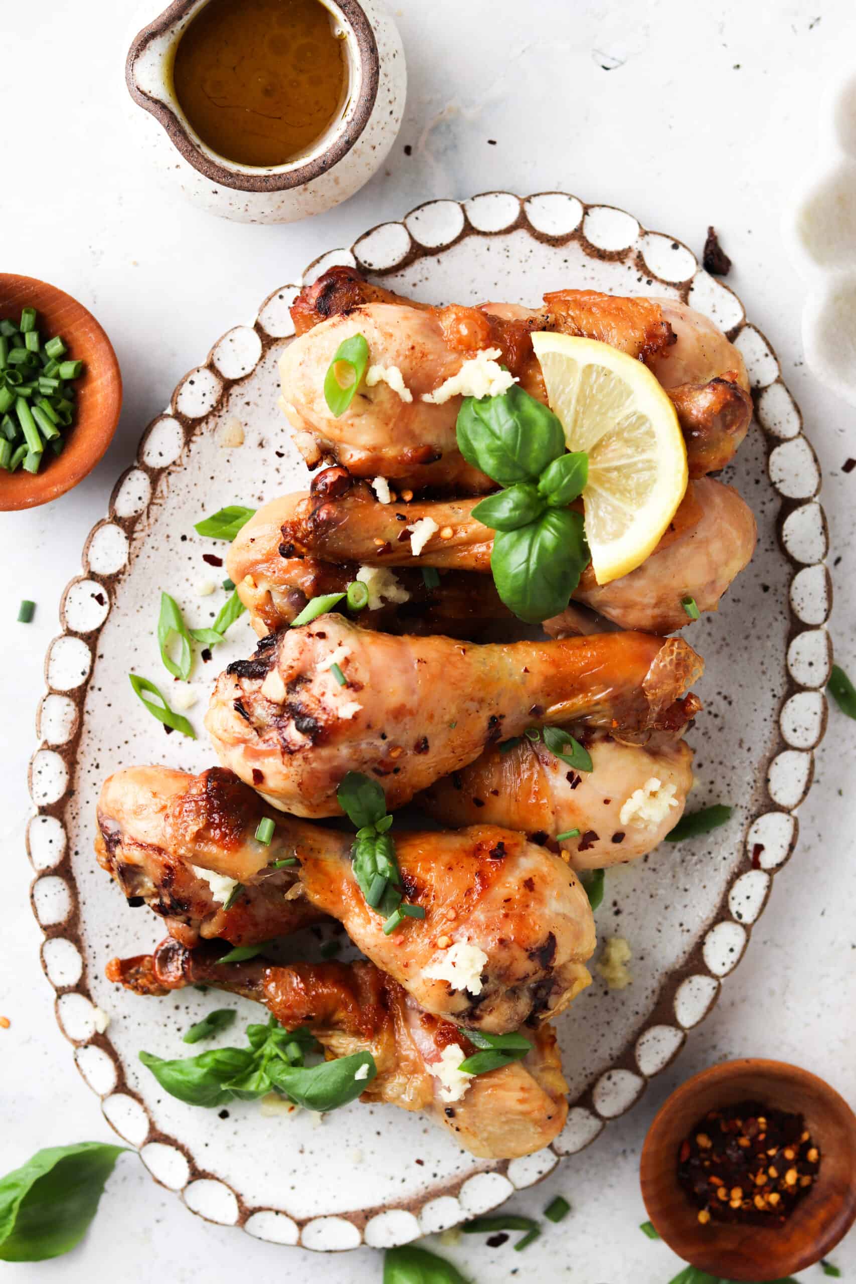 Chicken drumsticks on a plate with honey lemon garlic sauce.