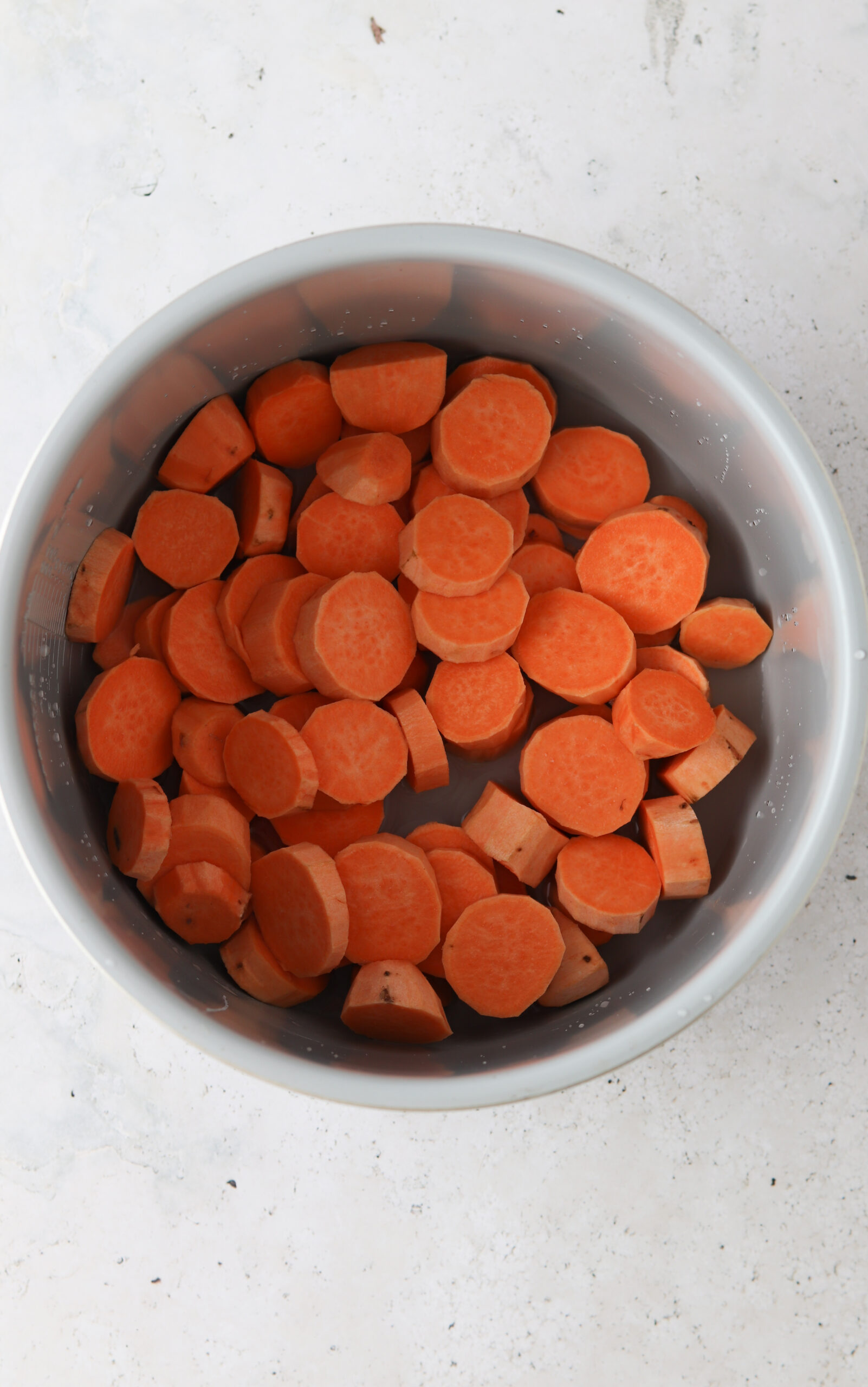 Chopped up sweet potatoes into a coin like shape inside an instant pot.