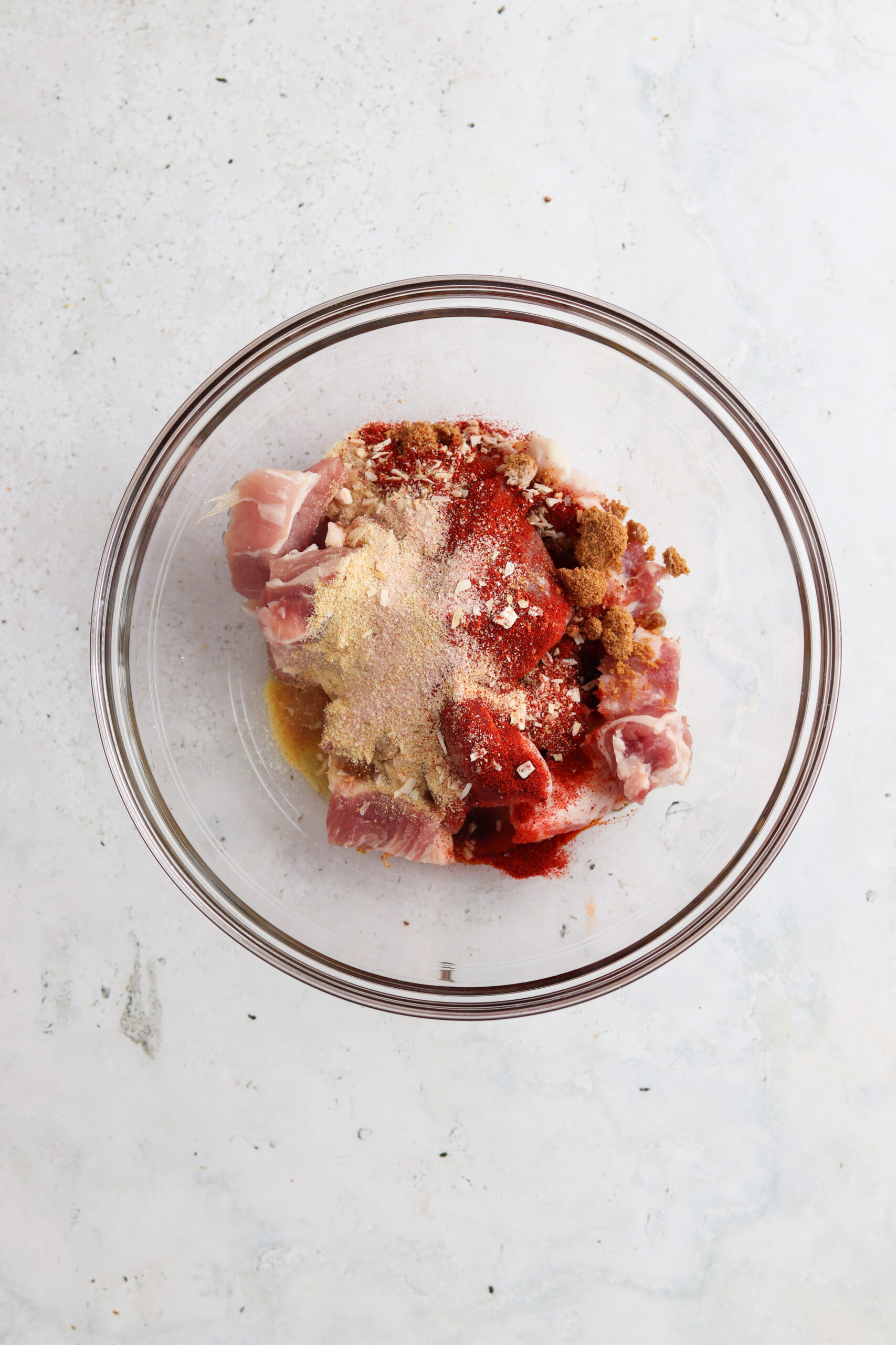 Pork belly marinating in a glass bowl.