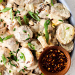 paleo potato salad on a plate with green onion on top