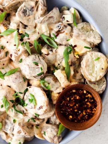 paleo potato salad on a plate with green onion on top