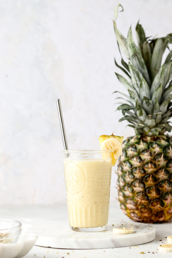 pineapple banana smoothie in a cup with a straw