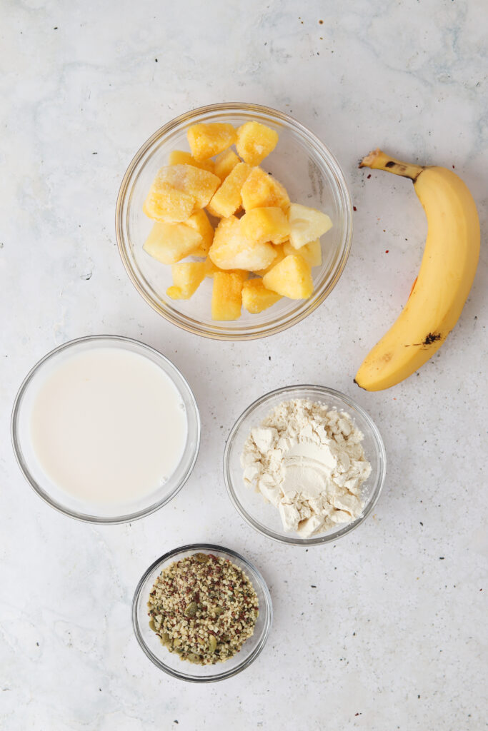 pineapple banana smoothie ingredients laid out in bowls