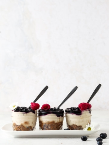 Vegan blueberry cheesecake jars on a tray.