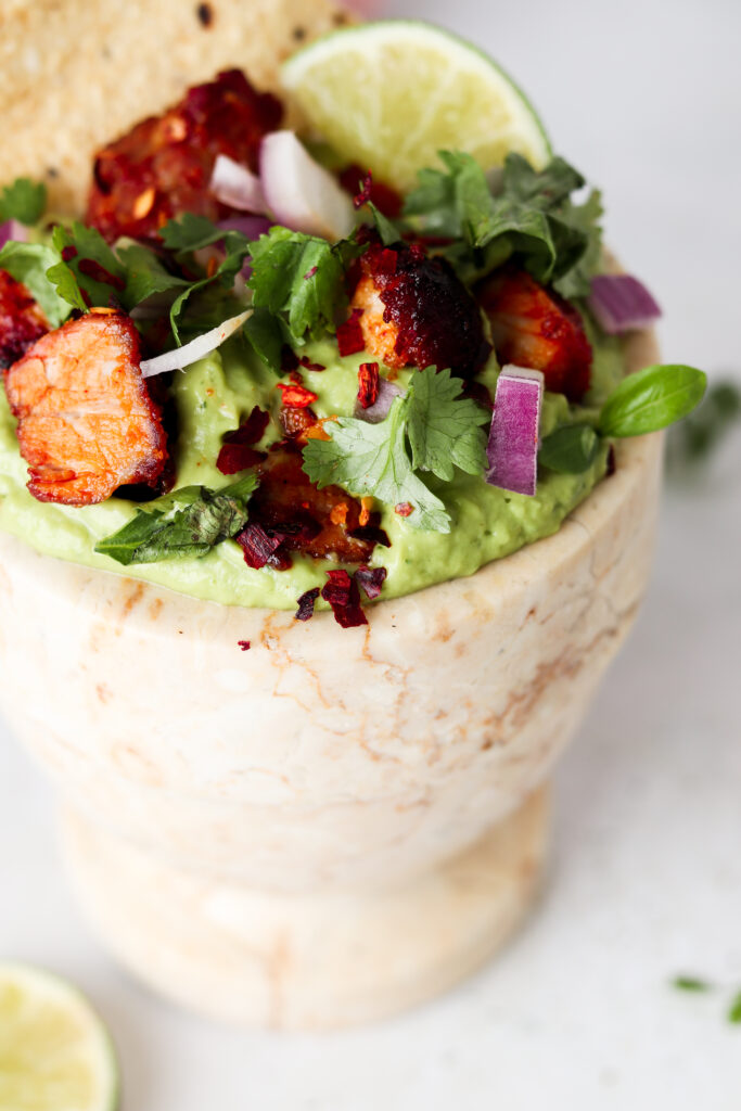 close up picture of guacamole with pork belly