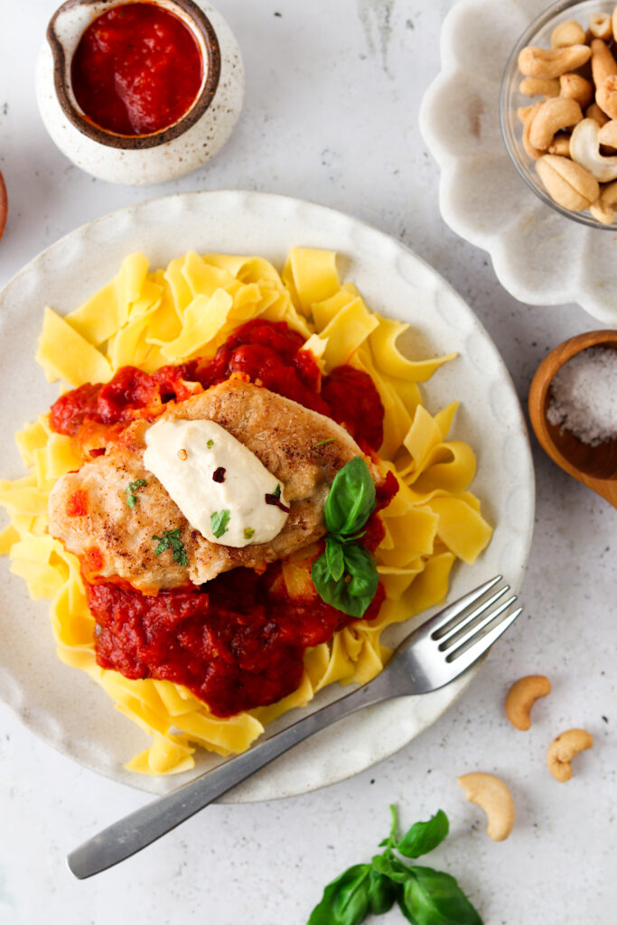 Paleo Chicken Parmesan on a white plate with basil