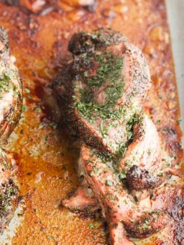 Braided pork on a baking sheet marinated with spices and oil.