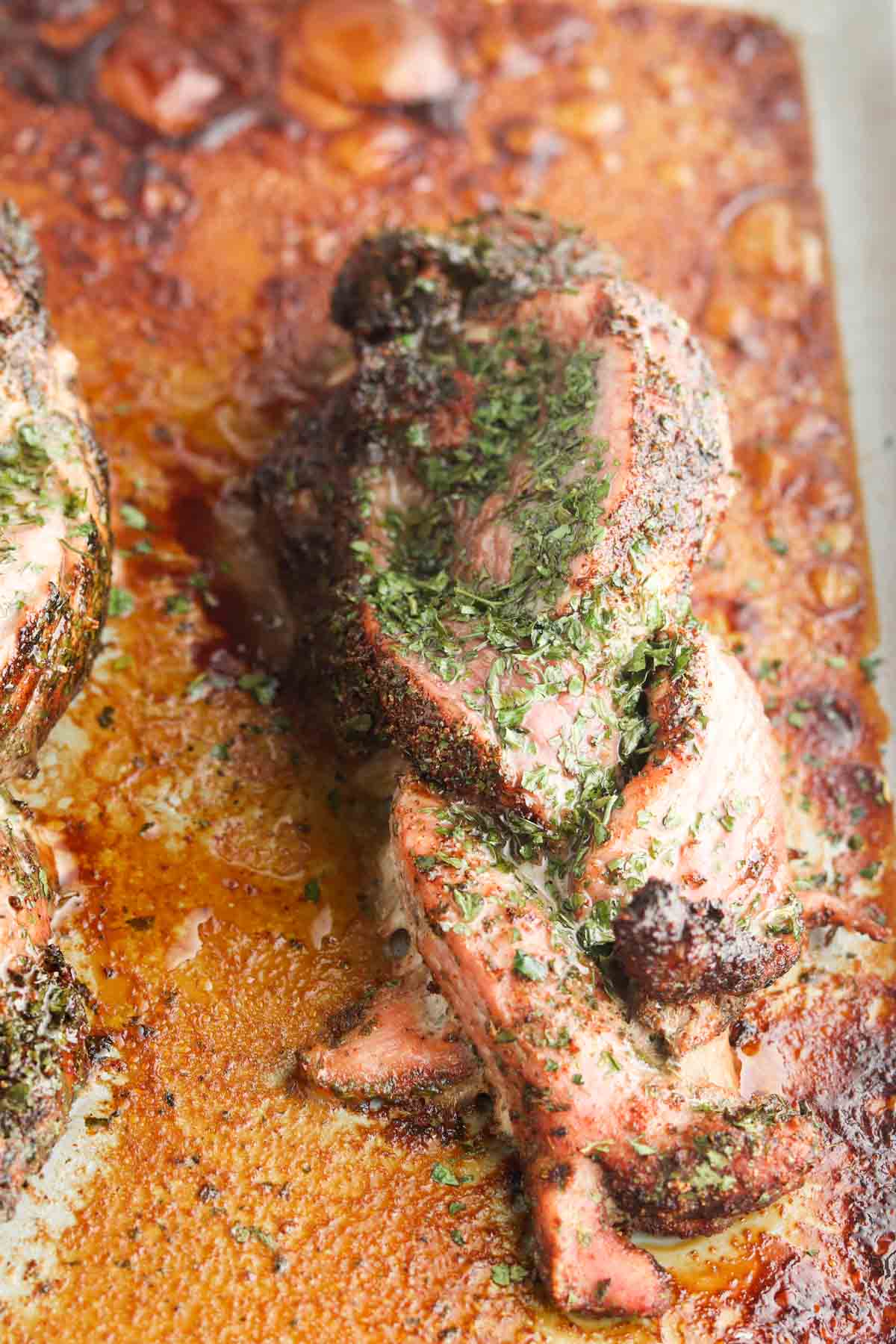Braided pork on a baking sheet marinated with spices and oil.