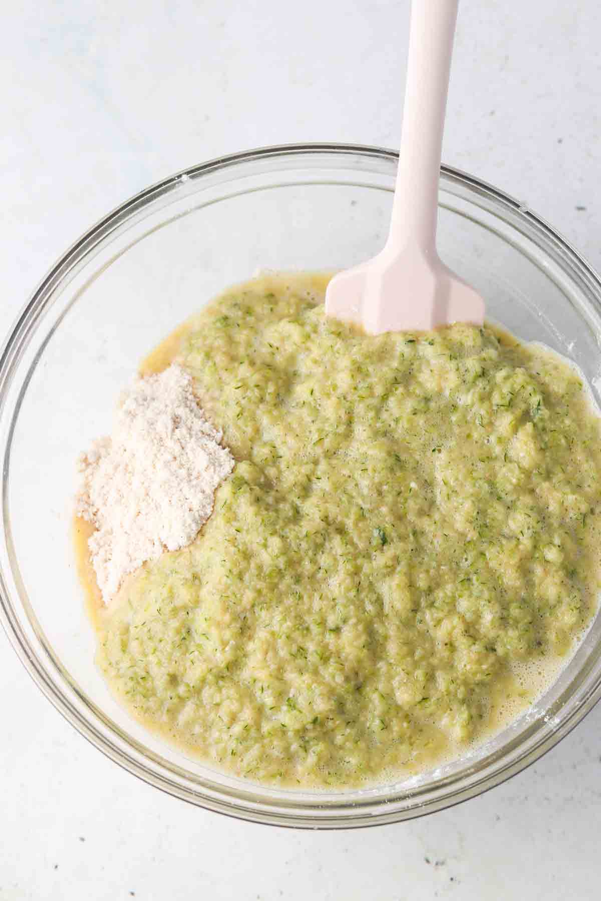 Wet and dry zucchini bread ingredients mixed together in a large bow.