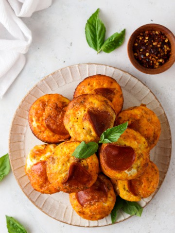 pizza egg muffins on a plate with basil