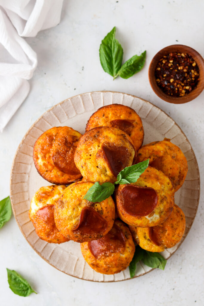 pizza egg muffins on a plate with basil