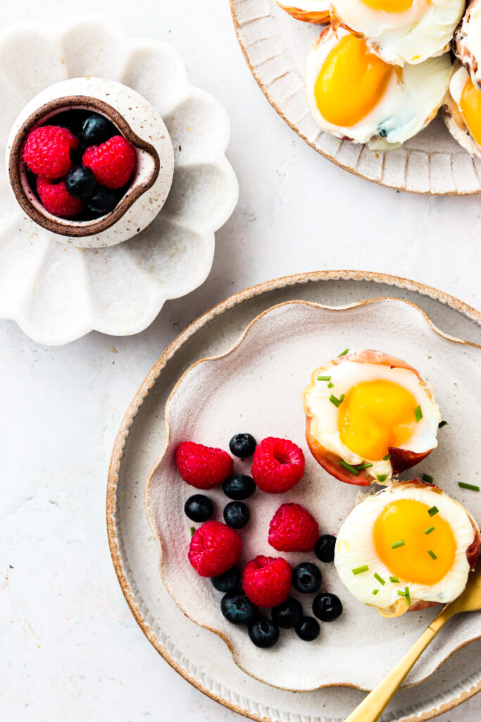 Prosciutto Egg Cups on a plate with fruit