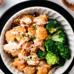 paleo bang bang shrimp with dairy free bang bang sauce in a bowl with broccoli