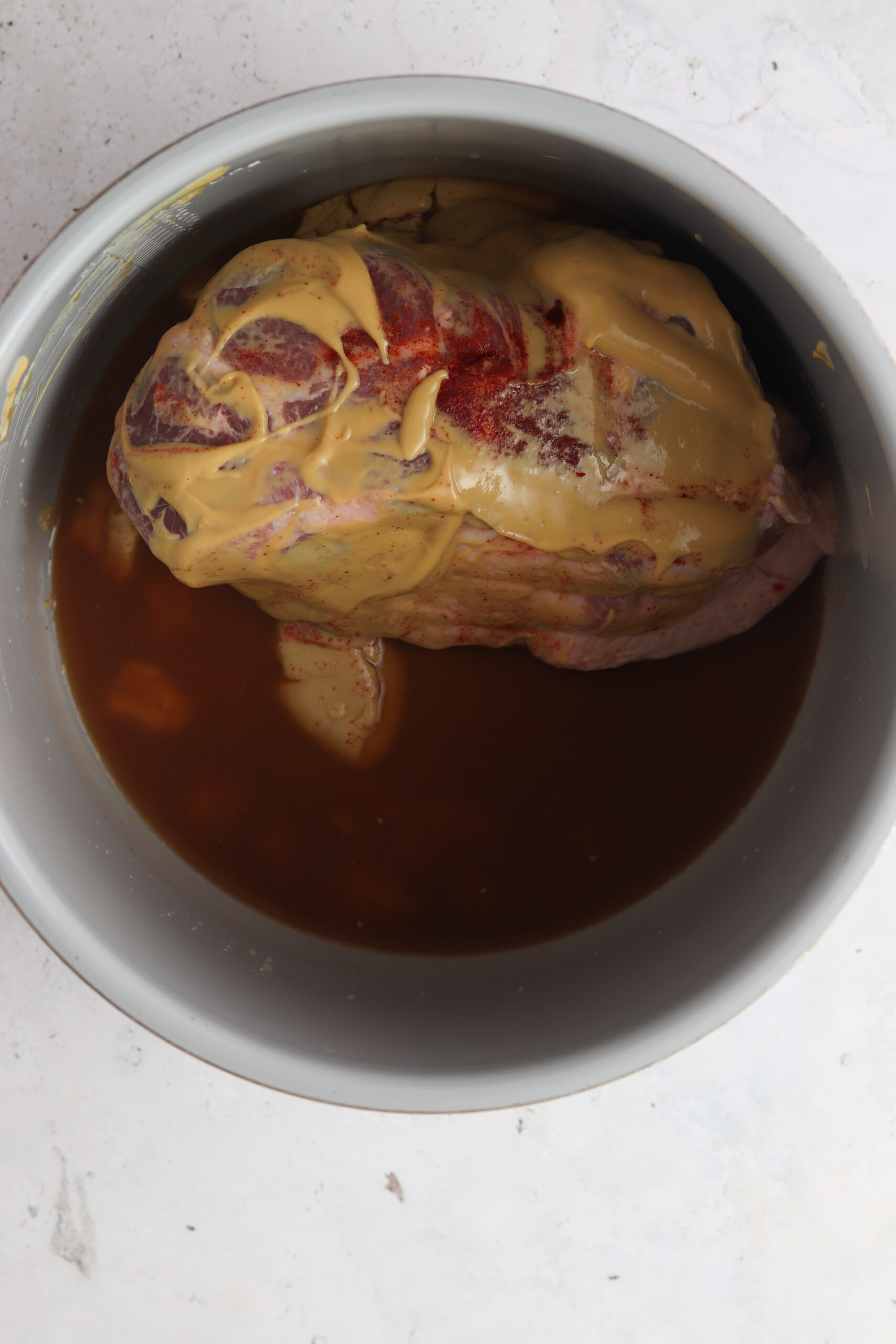 Raw pork butt with honey mustard coating in an instant pot.