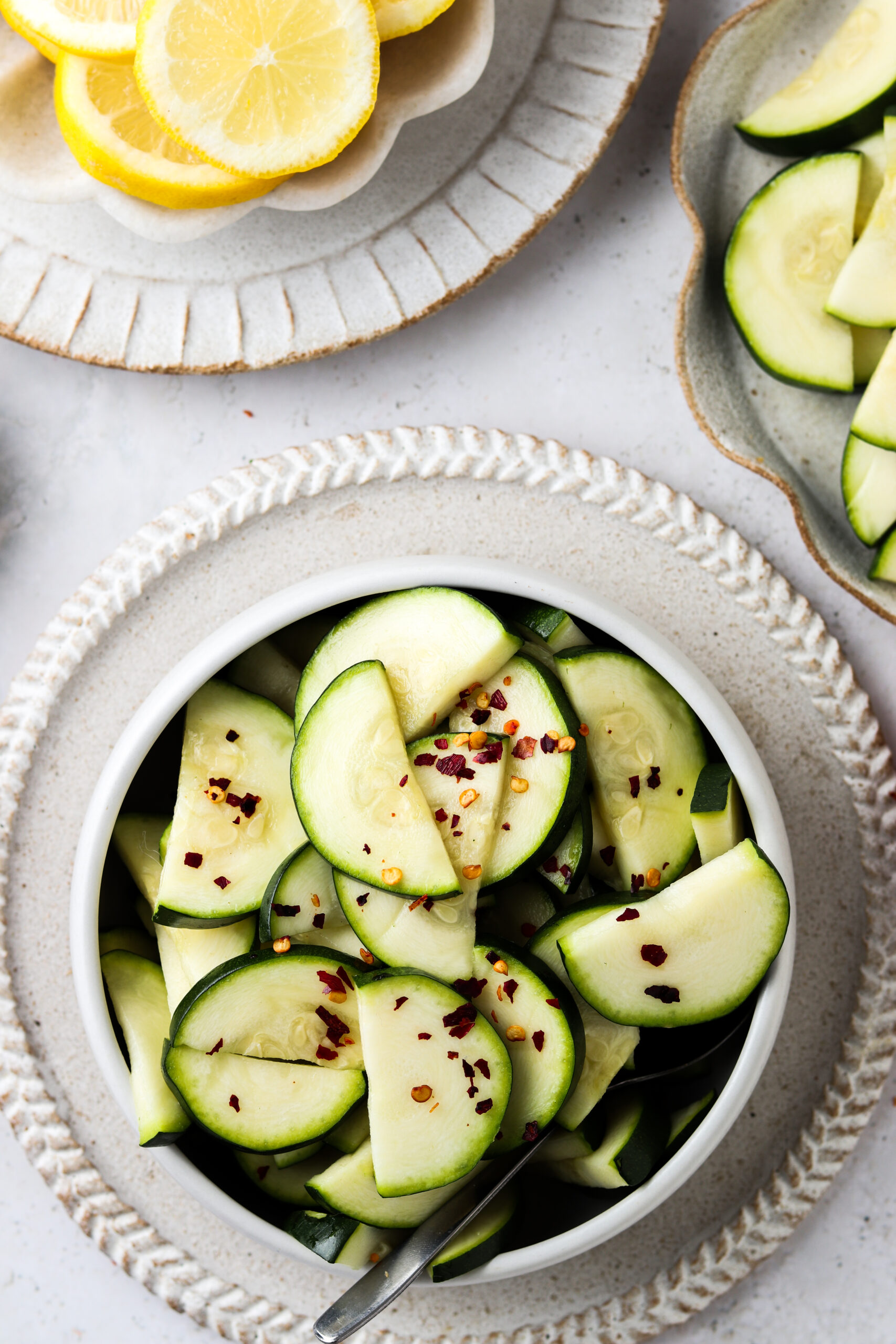 Instant pot lemon zucchini in a bowl garnished with red pepper flakes. 