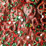 Chocolate covered pretzels on a sheet pan with sprinkles on top.