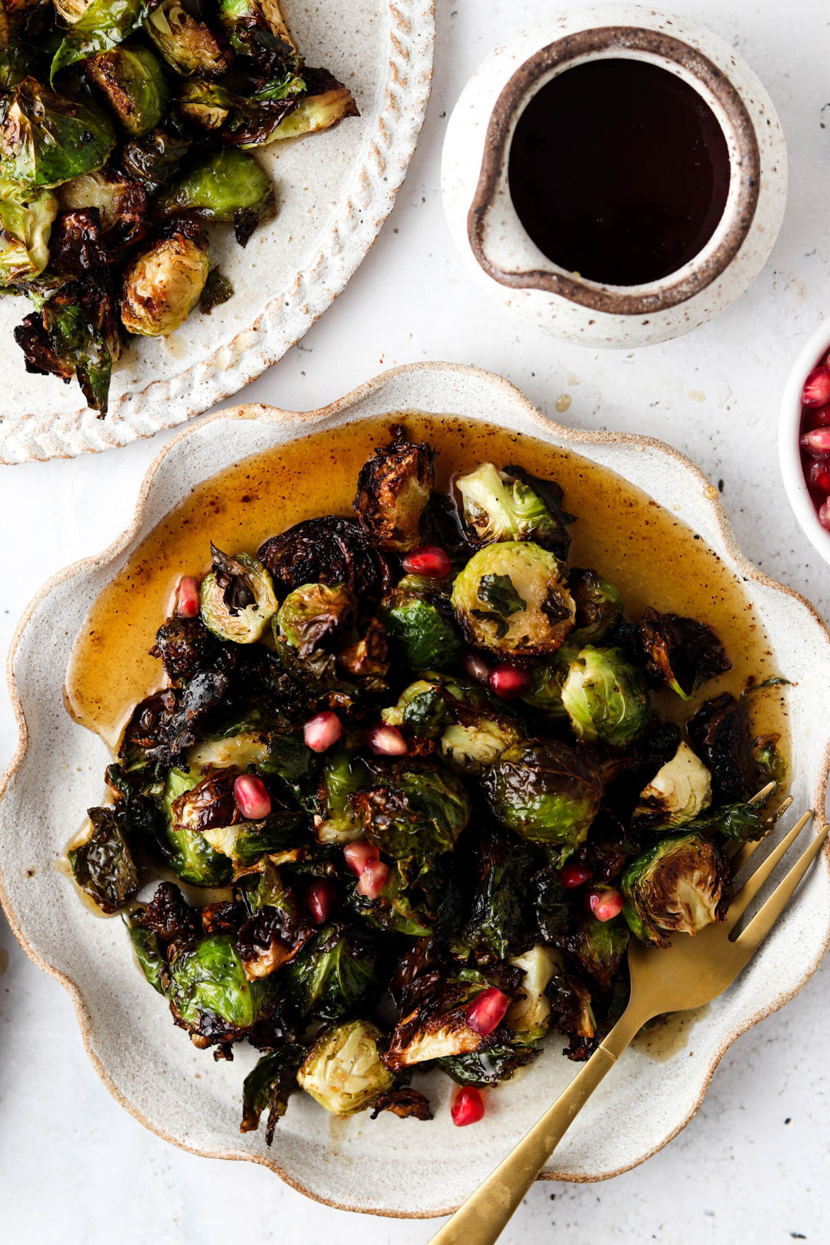 Balsamic maple brussel sprouts on a plate with a gold fork.