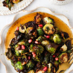 maple brussel sprouts on a plate with pomegranate