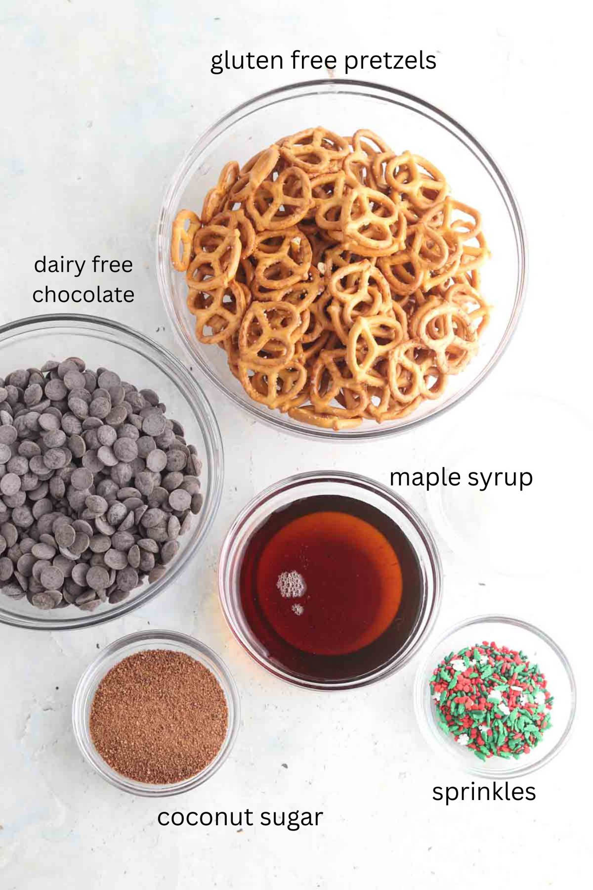 Pretzel Christmas Crack ingredients laid out on the counter in glass bowls. 