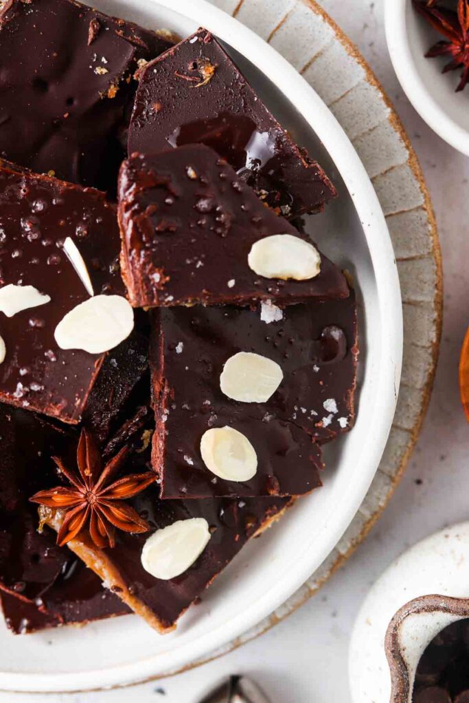 gluten free christmas crack on a plate garnished with almond slices and whole star anise 