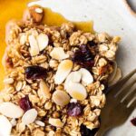 cranberry oat bars in a plate with a gold fork