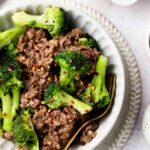 keto beef and broccoli in a bowl with a bowl with red pepper flakes