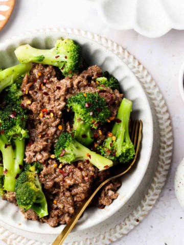 keto beef and broccoli in a bowl with a bowl with red pepper flakes