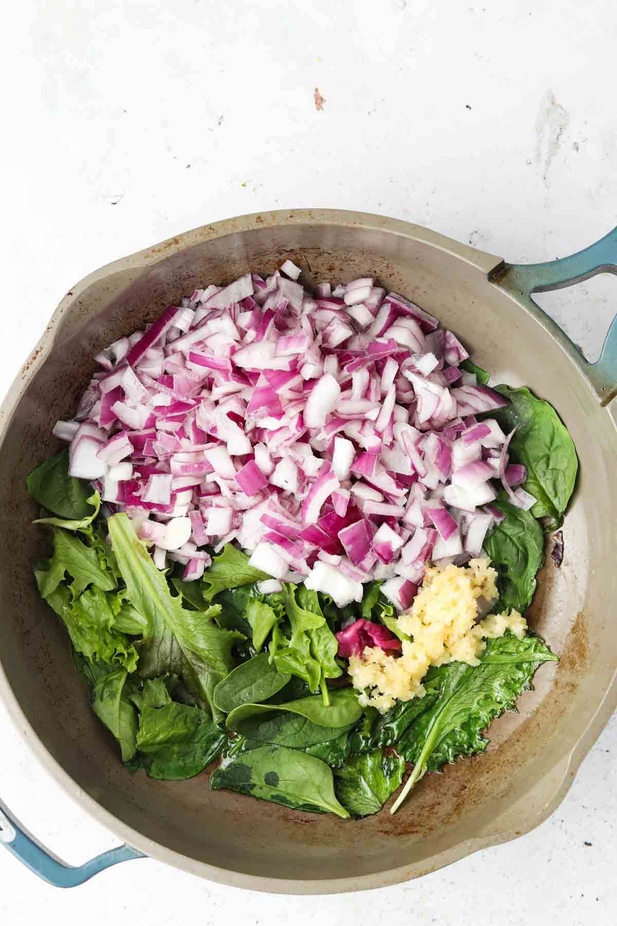 Onions, garlic and spinach in a pan.