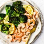 lemon garlic butter shrimp on a plate with broccoli