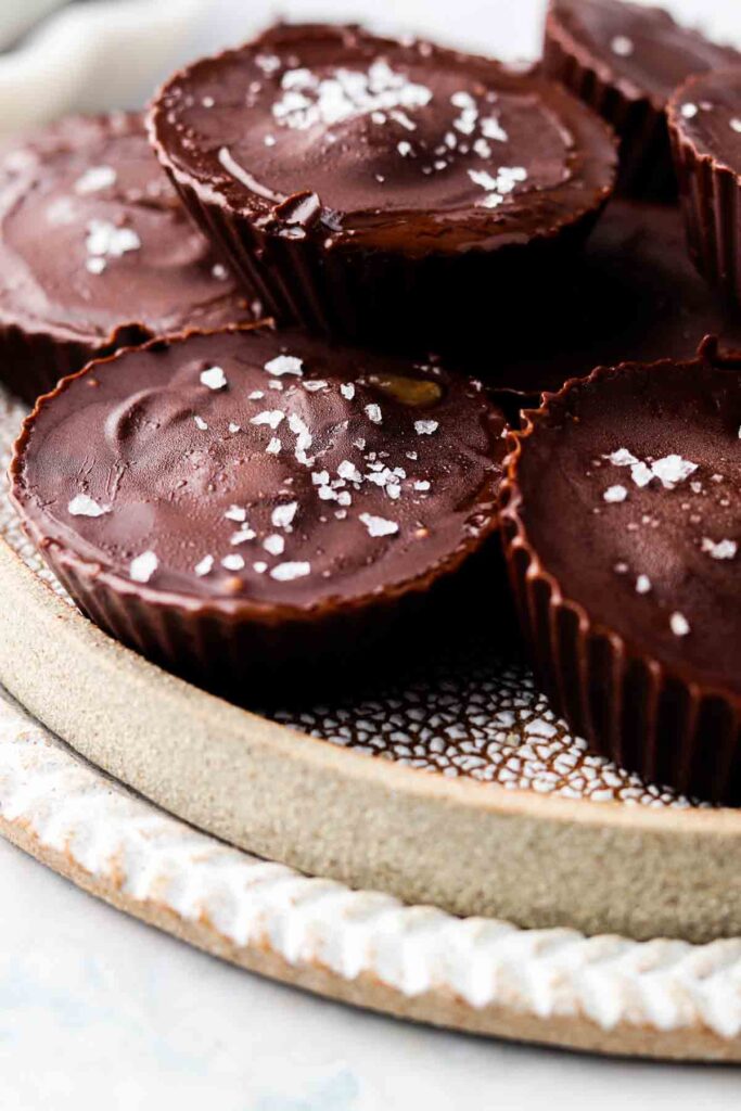 paleo almond butter cups on a plate with sea salt on top