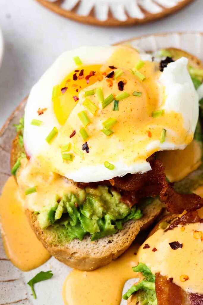 close up photo of hollandaise sauce over paleo eggs benedict