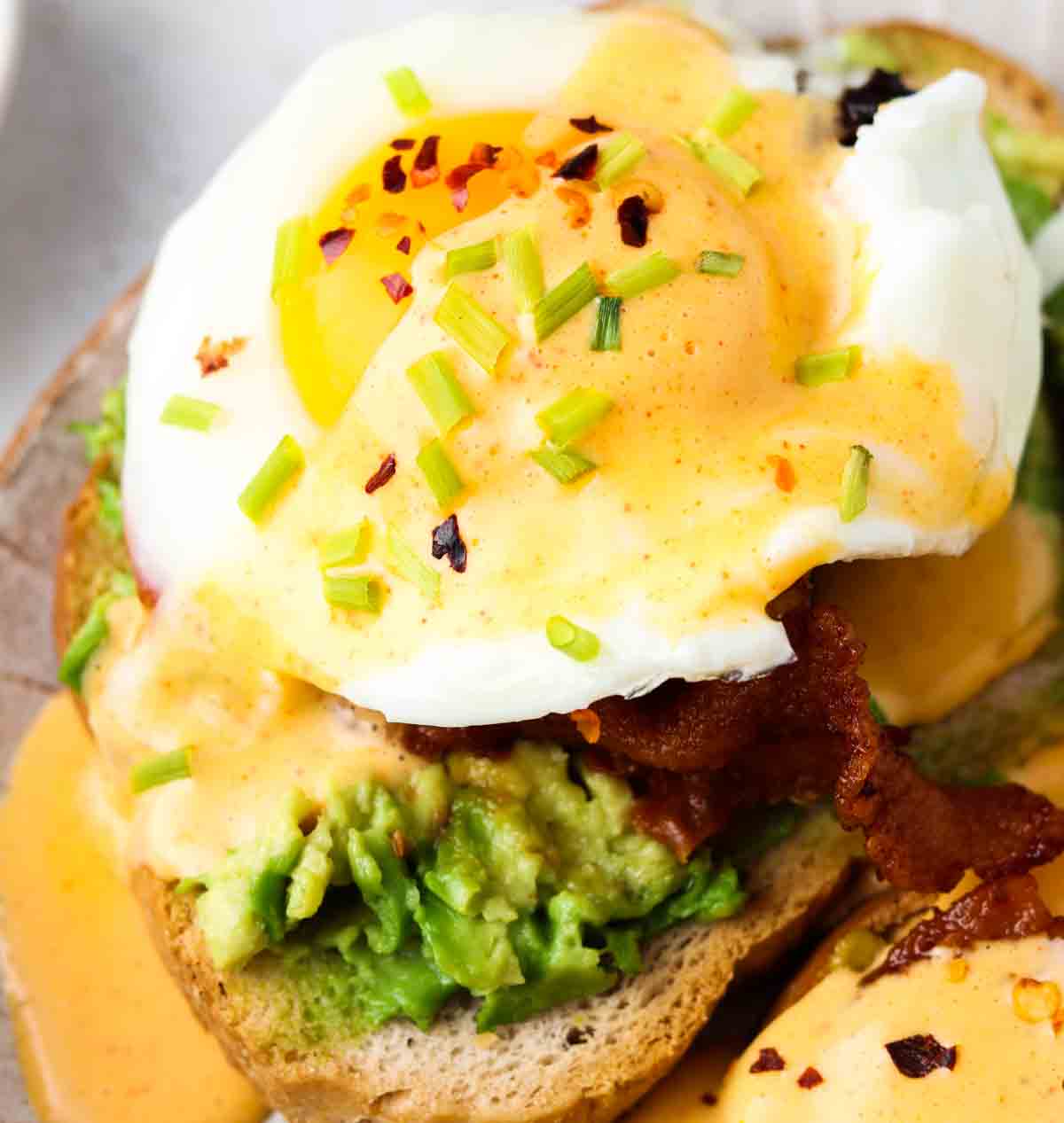 Paleo hollandaise sauce on toast with smashed avocado and bacon.