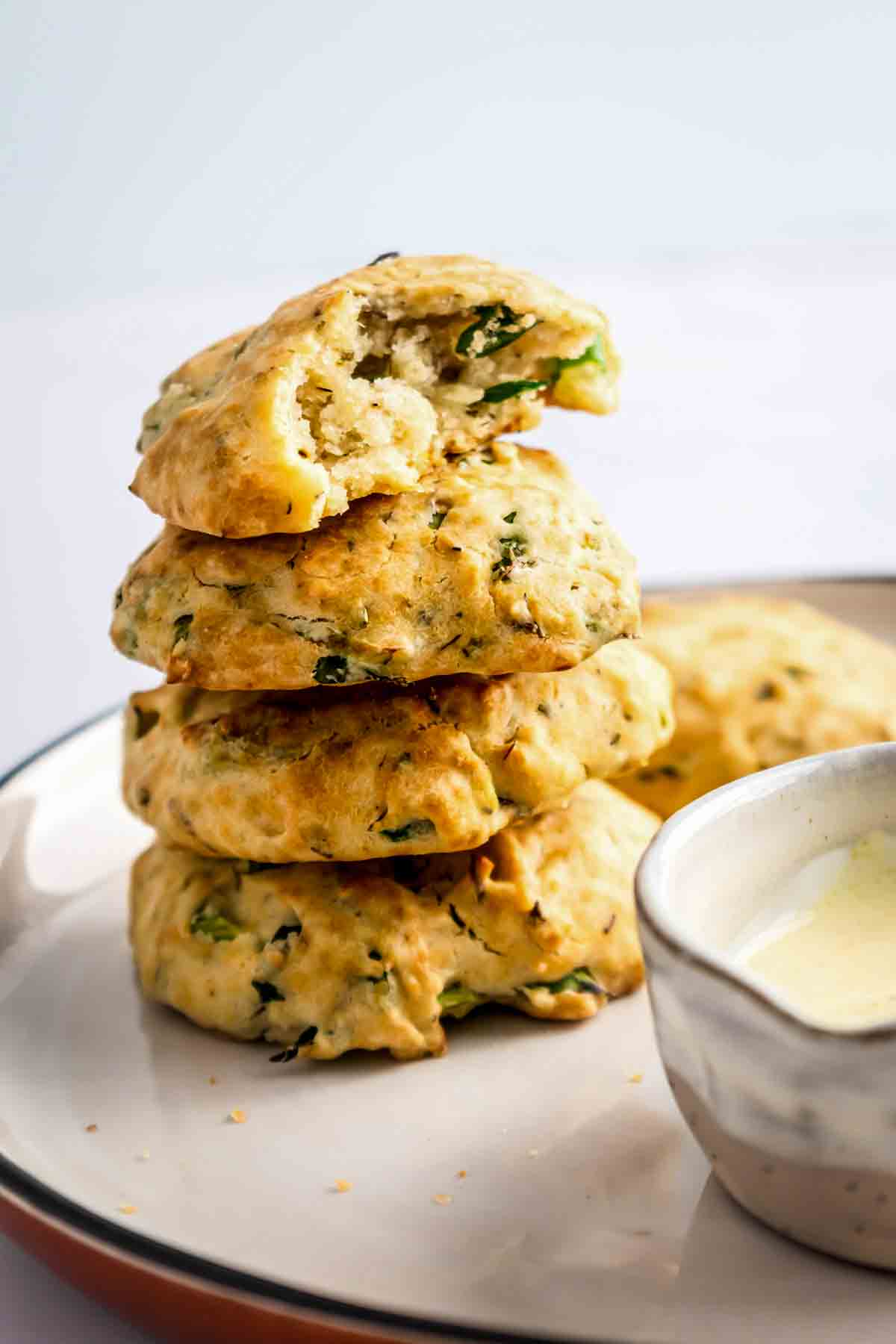 4 aip paleo bread rolls stacked on a plate.