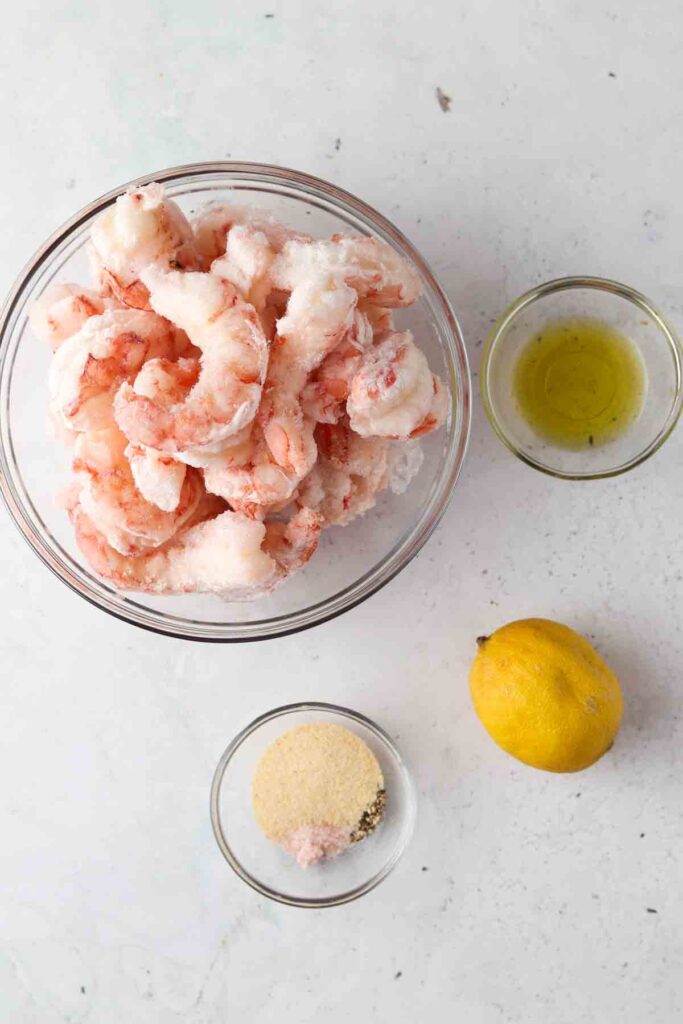 shrimp, lemon and spices in bowls on the counter