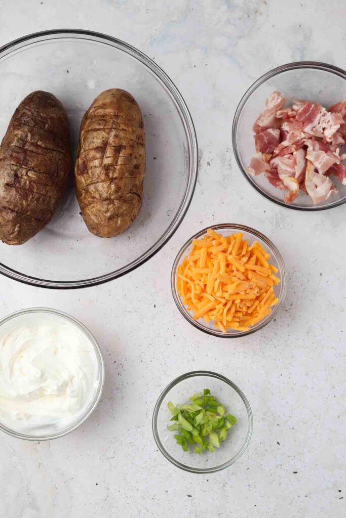 air fryer potato skin ingredients in bowls laid out on the counter