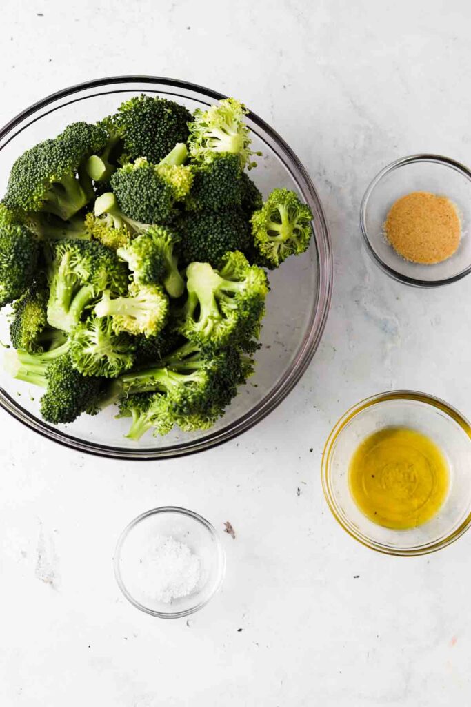 frozen broccoli, sea salt, garlic powder and olive oil in bowls