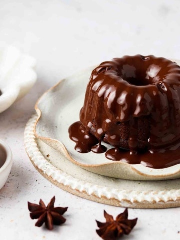 mini gluten free bundt cakes on a plate with chocolate ganache