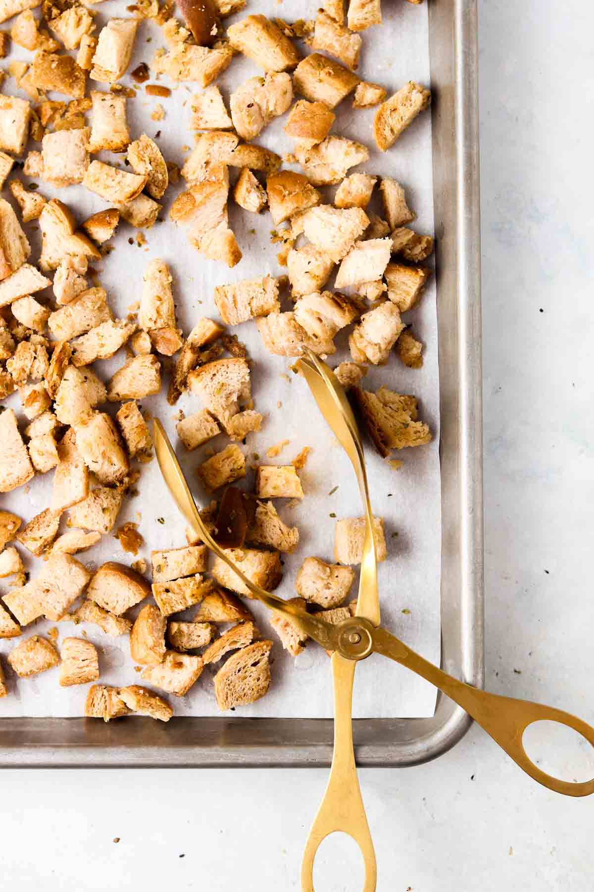 Baked gluten free croutons with tons on a baking sheet.